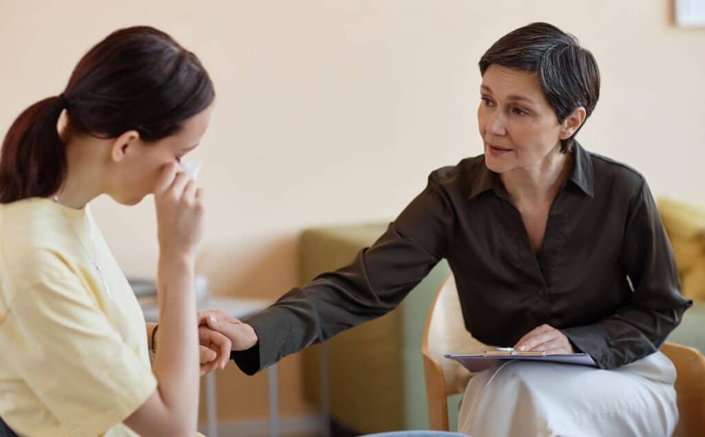 Professional supporting client during a session of therapy in Michigan.