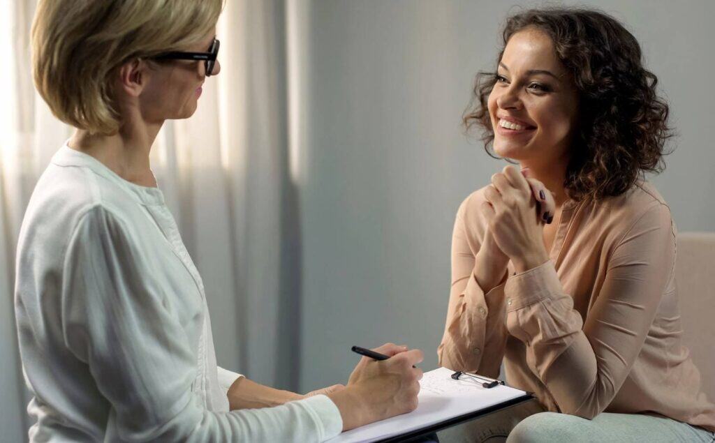 Woman talking with therapist for PTSD treatment in Michigan.