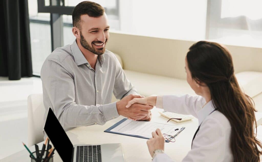 Man meeting with a specialist to understand how insurance covers rehab in Michigan.