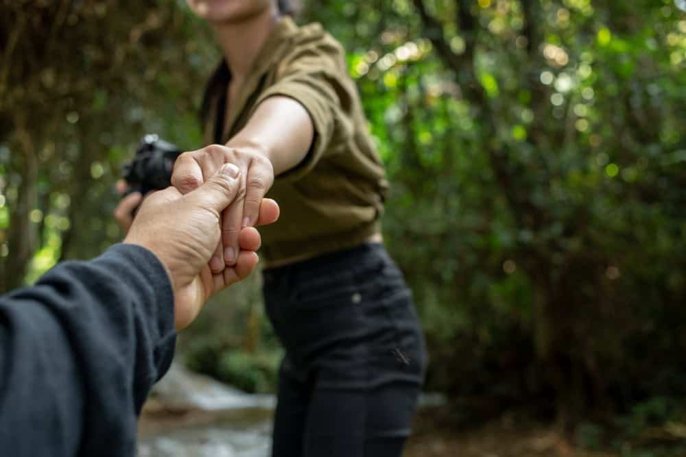People holding hands while supporting a loved one entering rehab treatment