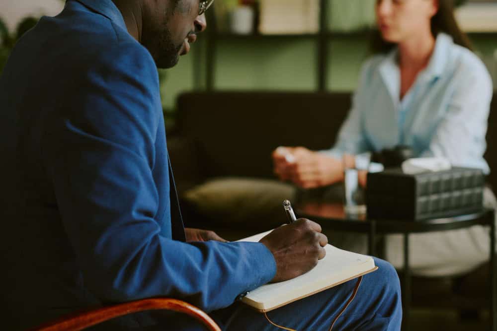 Man taking notes during consultation at rehab near Novi Michigan program