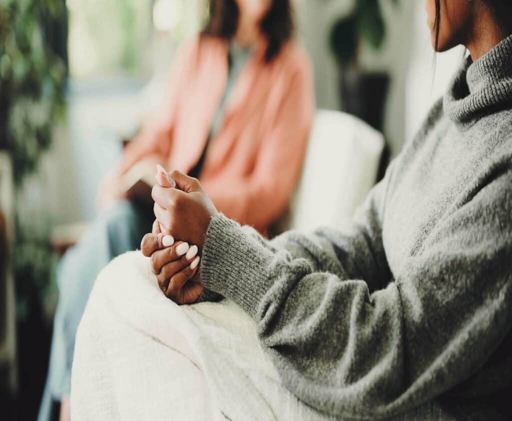 Woman receiving support during trauma and addiction treatment counseling session at Enlightened Recovery Michigan